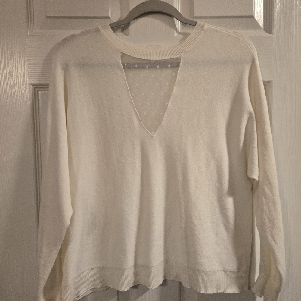 White sweater w/ lace detail on neck/chest area.